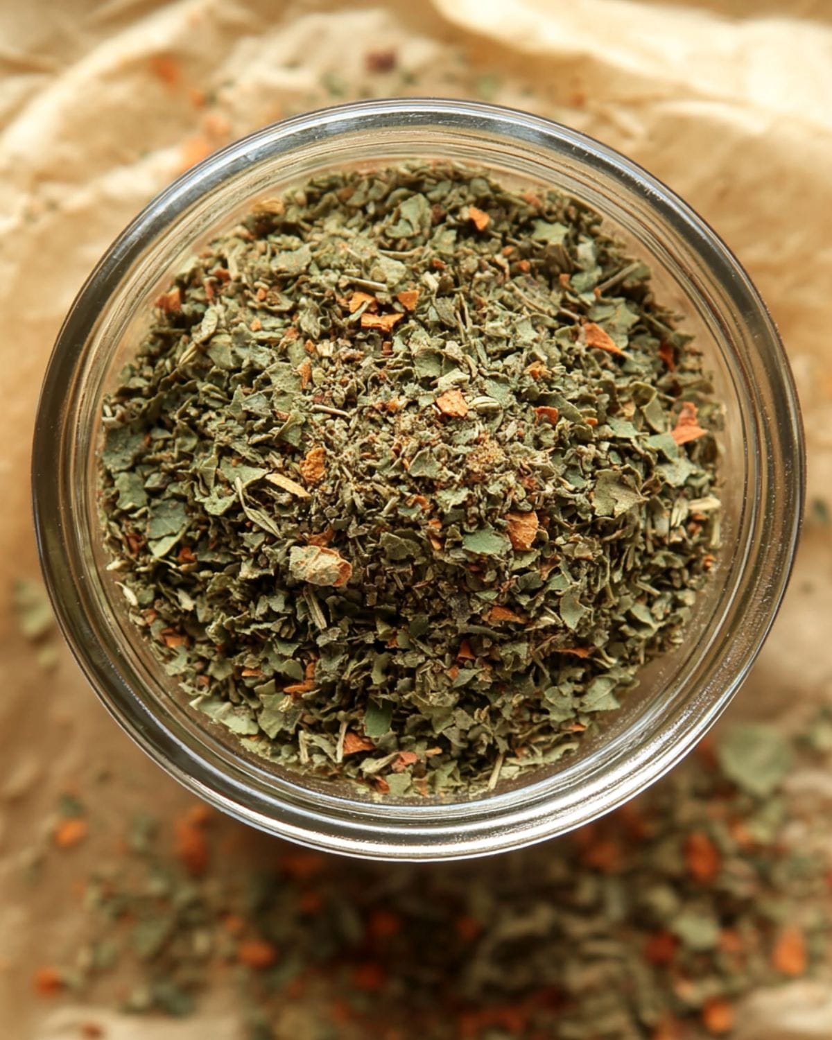 homemade spaghetti seasoning Glass jar filled with aromatic homemade spaghetti seasoning blend on parchment paper